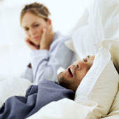 woman trying to block out the snoring of her husband